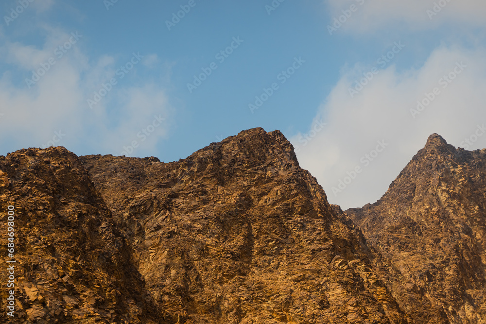 Fujairah mountains, extension of Omani Al Hajar mountain range. Cloudy winter day on empty street.