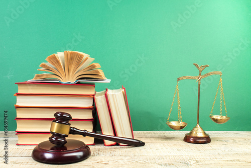 Law concept - Open law book, Judge's gavel, scales on table in a courtroom or law enforcement office.