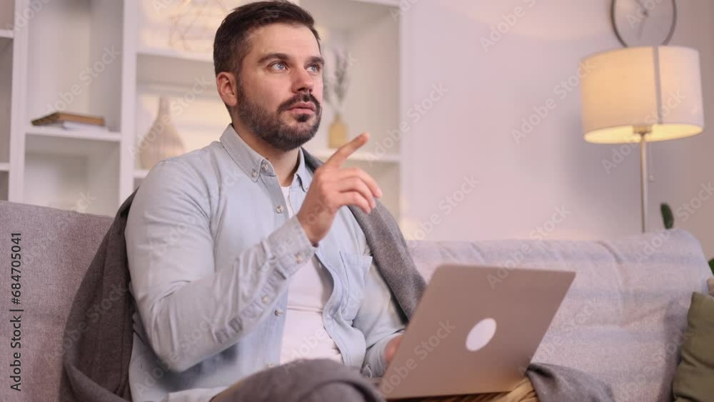 Portrait of creative mature man freelancer hold laptop and thinks questioningly about difficult choice choose imagine plan in mind has doubts create idea sitting on couch at home Portrait of creative mature man freelancer hold laptop and thinks questioningly about difficult choice choose imagine plan in mind has doubts create idea sitting on couch at home