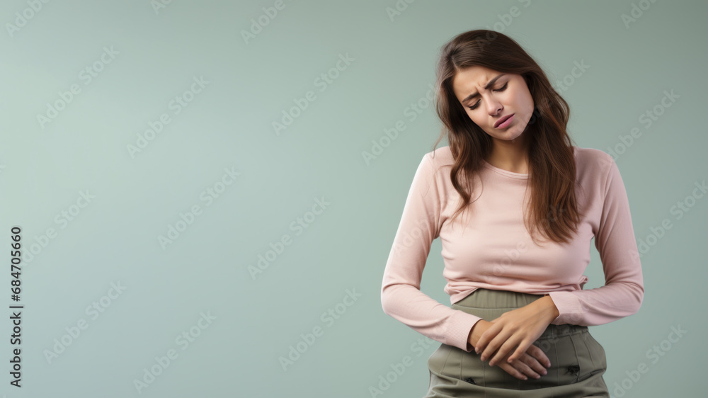 Obraz premium Brunette woman wincing in pain and hand rubbing stomach