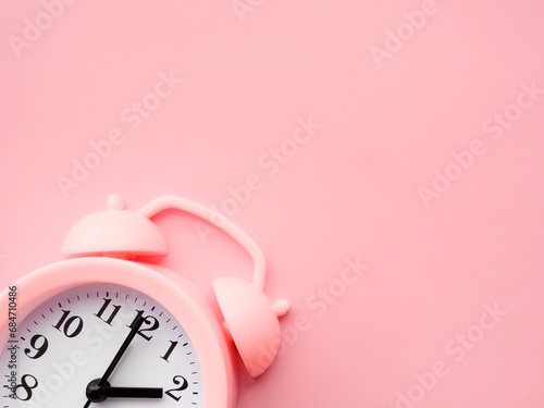Pink background with alarm clock at 2am 2pm and copy space to add text 