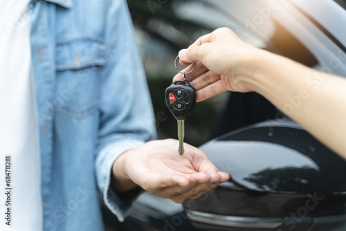 Photos Buy second-hand auto or rent a car concept, Close-up hand of used car agent giving an auto key to client