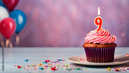 Birthday cupcake with lit birthday candle Number nine for nine years or ninth anniversary photo