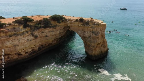 Natural arch above ocean, Arco de Albandeira, Algarve, Portugal. Stone arch at Praia de Albandeira, Lagoa, Algarve, Portugal. View of the natural arch Arco da Albandeira in the Algarve, Portugal.