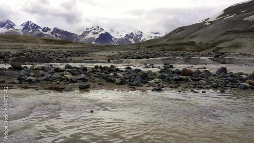 River flowing through The Valley of Ten Thousand Smokes in Katmai National Park and Preserve in Alaska. Valley between mountains is filled with ash flow from Novarupta eruption in 1912. Erosion of ash