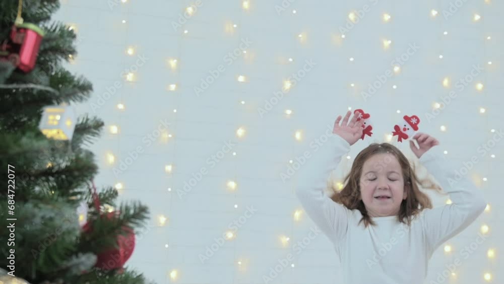 two happy girls, children in Santa hats jumping on the bed and fighting with pillows against the backdrop of Christmas decorations. High quality FullHD footage
