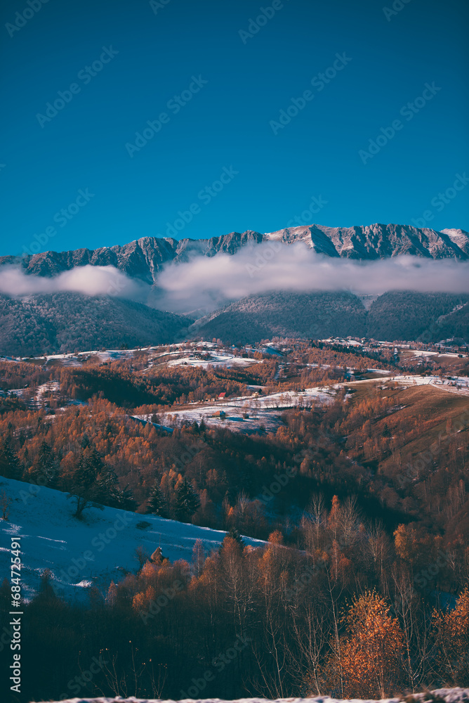 Winter landscape with snow-covered hills and mountains background. Human settlements in wild areas. Villages located in tourist areas