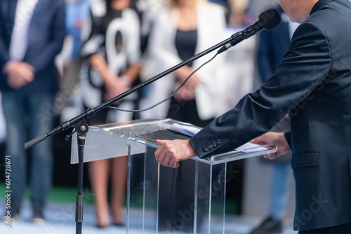 Fair's lively atmosphere, a compelling male speaker addresses a captivated audience during a powerful speech