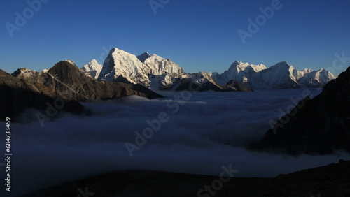 Sea of fog in the Gokyo Valley and sun lit high mountains, Nepal. photo