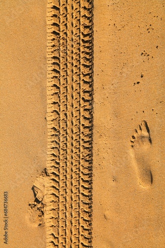 Car tyre tracks imprinted on beach sand