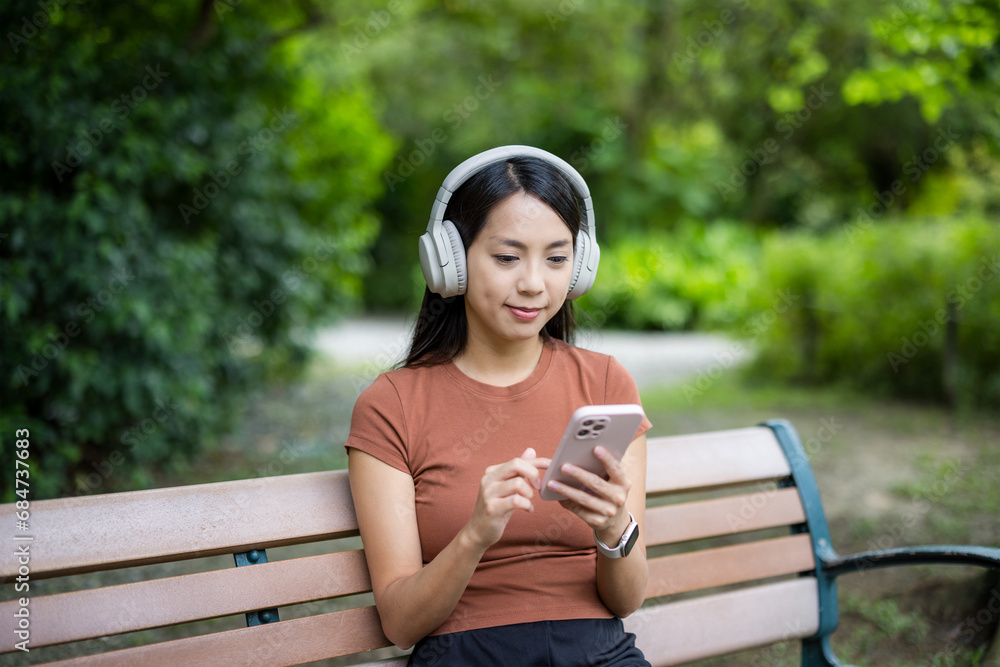 Obraz premium Woman use of mobile phone and sit inside park