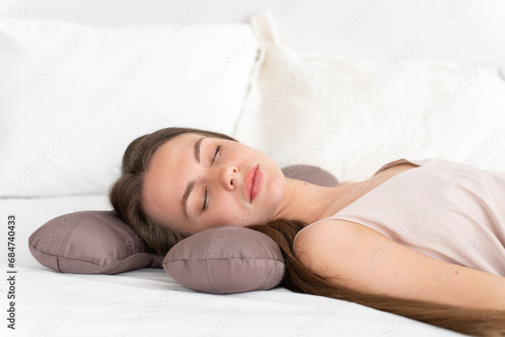 Caucasian girl 20-25 years old in silk lingerie sleeps on a beauty pillow on bed in the bedroom Caucasian girl 20-25 years old in silk lingerie sleeps on a beauty pillow on bed in the bedroom