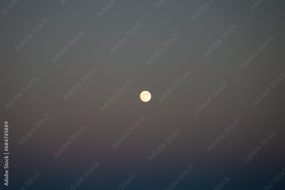 Full moon against a subtitle sunset sky. Full moon against a subtitle sunset sky.