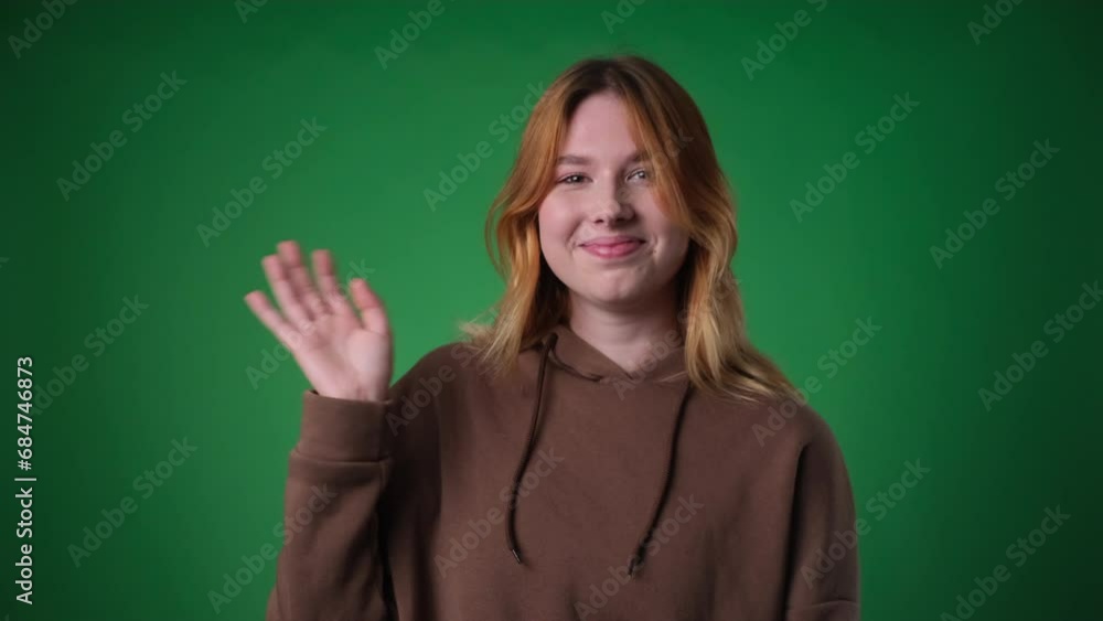 Red haired Woman Waving Hand on Green Background Red haired Woman Waving Hand on Green Background