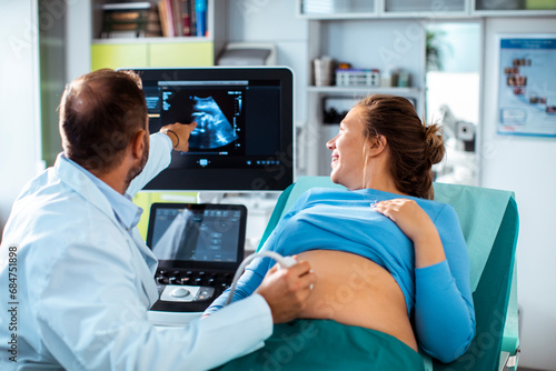 Pregnant woman undergoing ultrasound test at hospital by doctor photo