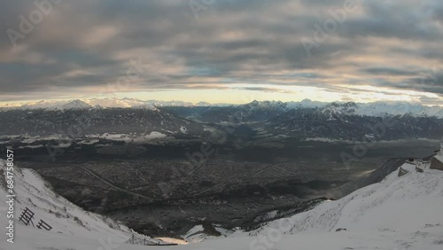 PAN SLOW SHOT - View from the Hafelekarspitze mountain over the city of Innsbruck, Austria, the Inn Valley, and the landscapes beyond. photo