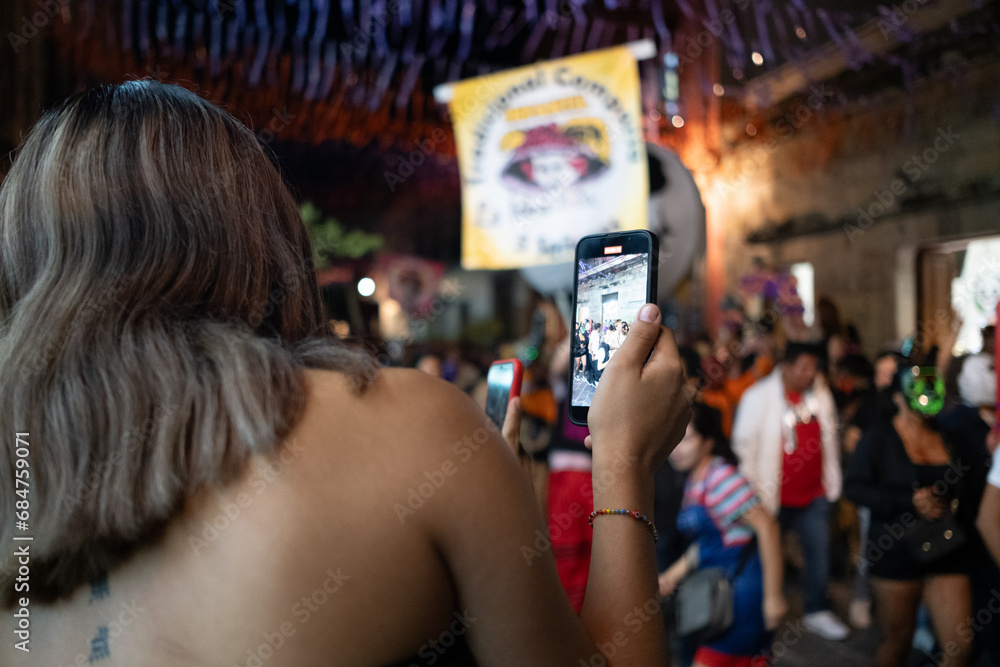 blond young girl filming with smartphone party on the street for social media posting blond young girl filming with smartphone party on the street for social media posting