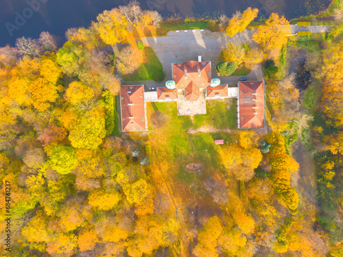 Aaerial view on the beautiful palace in Autumn sunset. White palace in the autumn forest. High altitude. photo