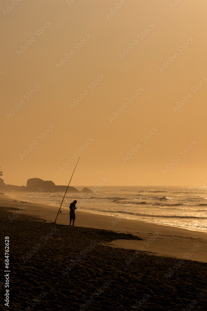 Silhueta de pescador, hora dourada, amanhecer na praia