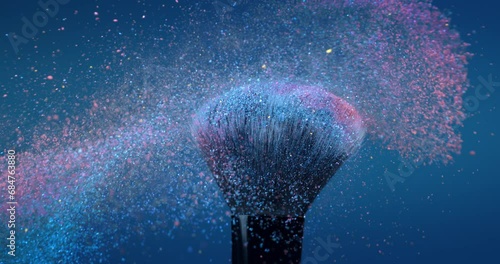 Super slow motion macro of make up brushes with flying colorful cosmetic product powder dust particles splash explosion isolated on soft dark background. photo