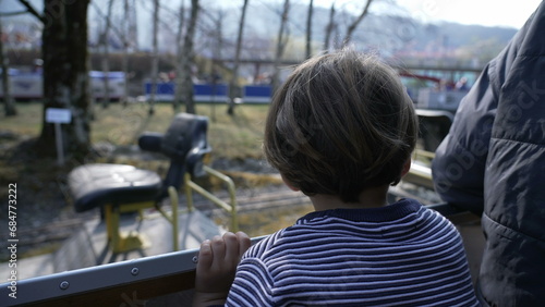 Young Passenger Small Boy Watches Scenery Pass by on Miniature Train Ride at Swiss Vapeur Park © Marco