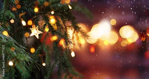 Christmas tree with garland lights. Evening city with blurred background and bright lights