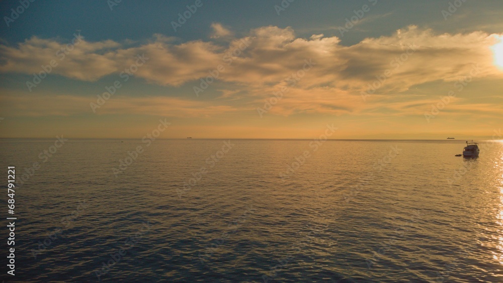 the sun shines down on the horizon of an ocean and boats