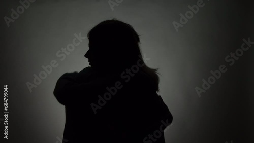 Silhouette of Embracing Young Couple on Gray Background
