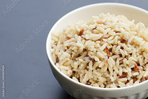 Cooked brown rice on dark background.