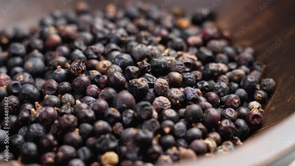 Wooden bowl with dried aromatic seeds of juniper plant close up. Rotation Wooden bowl with dried aromatic seeds of juniper plant close up. Rotation