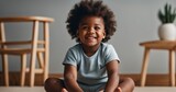 Happy African Baby Toddler Sitting On beige background Looking Aside At Free Space And Smiling Posing In Bedroom At Home. Banner With Child. Advertising template for children products