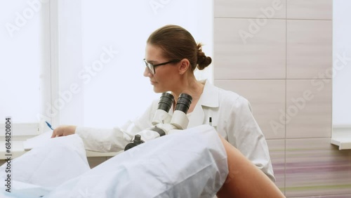 Female Gynecologist examining patient on chair with gynecological equipment. Colposcopy, examination of a cervical cancer. Colposcope close-up. Maternity fertility IVF issues. Abortion and ovulation photo