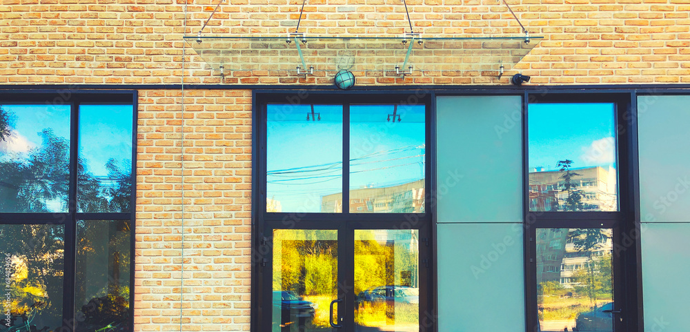 Modern real estate, residential apartment building, entrance with glass canopy, door and windows