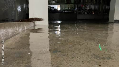 Close up view flooded cement ground at residential home at night. Natural disaster concept