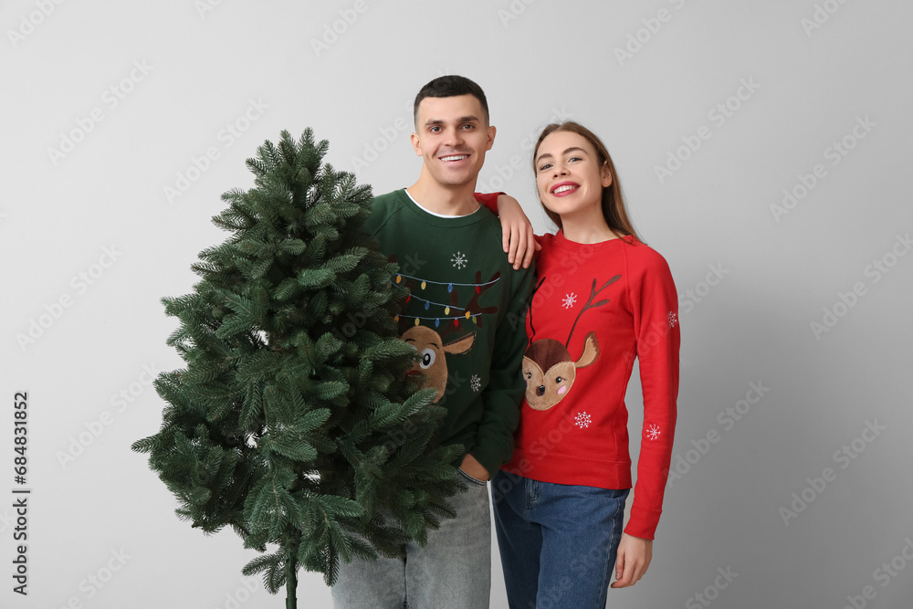 Happy young couple with Christmas tree on white background Happy young couple with Christmas tree on white background