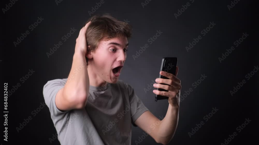 Man Celebrating Good News on Phone Against black Background Man Celebrating Good News on Phone Against black Background