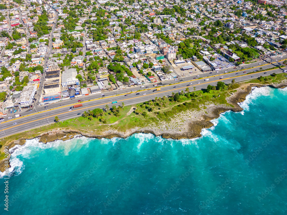 Aerial top view of The Autopista Las Americas along the rocky shore of turquoise caribbean sea. Expressway from the Santo Domingo este. 