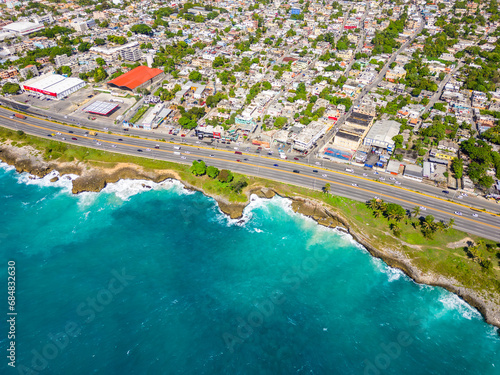 Aerial top view of Santo Domingo este. The Autopista Las Americas along the rocky shore of turquoise caribbean sea. Expressway to the capital city