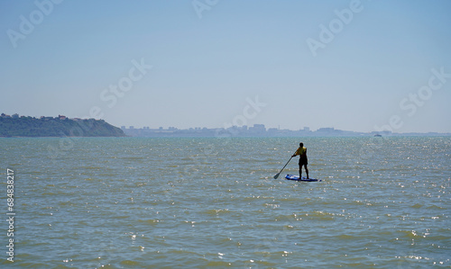 A lonely man, a man is sailing on a sap board on the sea, rowing with an oar