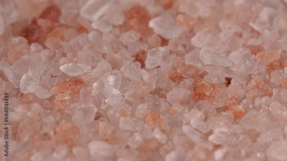 Pink himalayan salt or rock salt rotating macro background low light. Trace minerals salt used for cooking and food presentation, decorative lamps, and spa treatments Pink himalayan salt or rock salt rotating macro background low light. Trace minerals salt used for cooking and food presentation, decorative lamps, and spa treatments