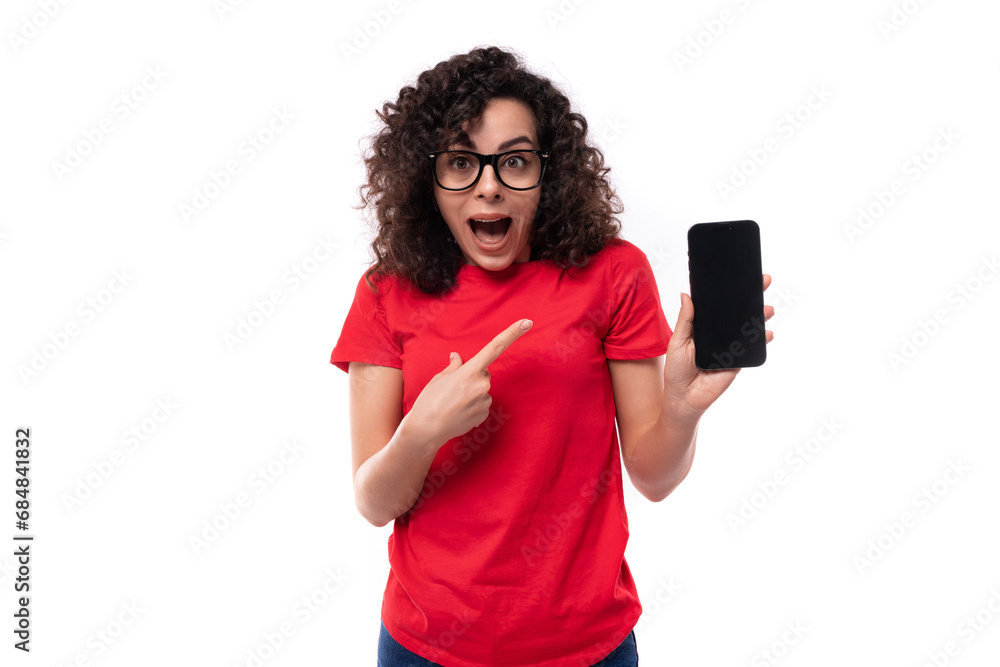 young surprised woman in glasses for vision dressed in a red basic t-shirt shows the screen of a smartphone with a mockup for advertising young surprised woman in glasses for vision dressed in a red basic t-shirt shows the screen of a smartphone with a mockup for advertising