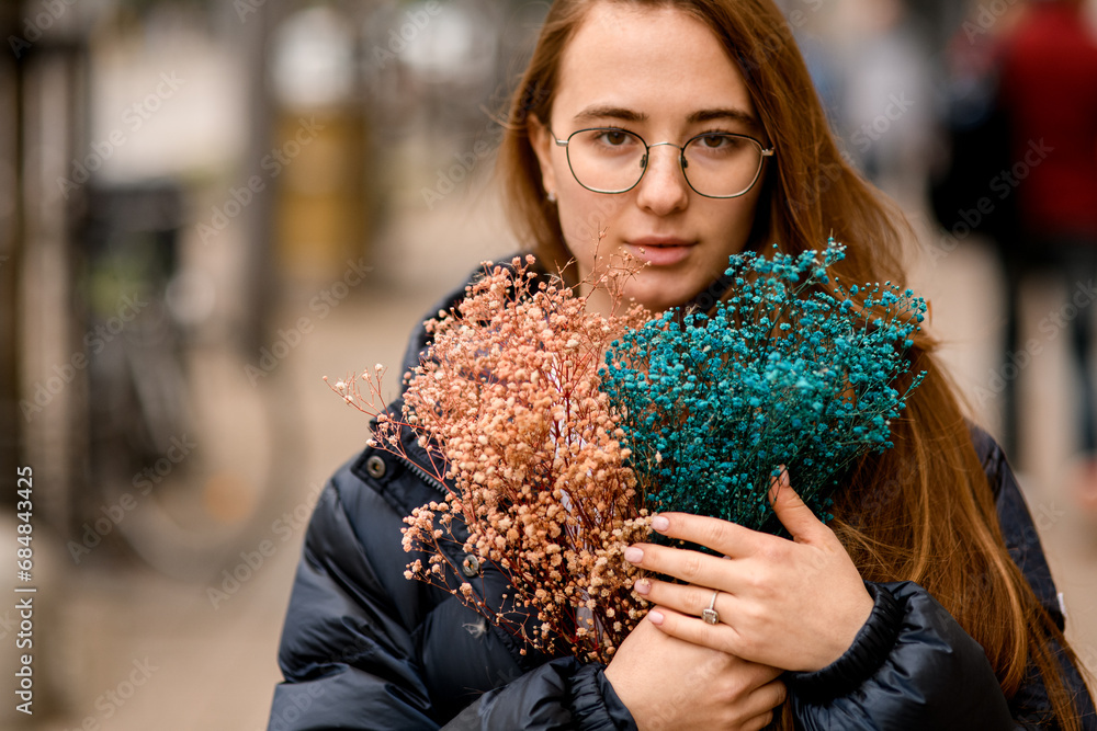 Ταπετσαρία Young pretty brown-haired girl stands on a city street with a bouquet