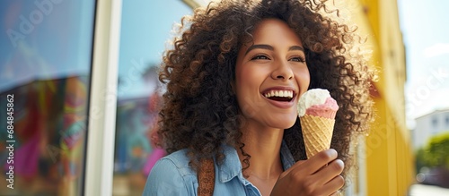 Happy Latin woman enjoying an ice cream cone after buying frozen yogurt at the shop.