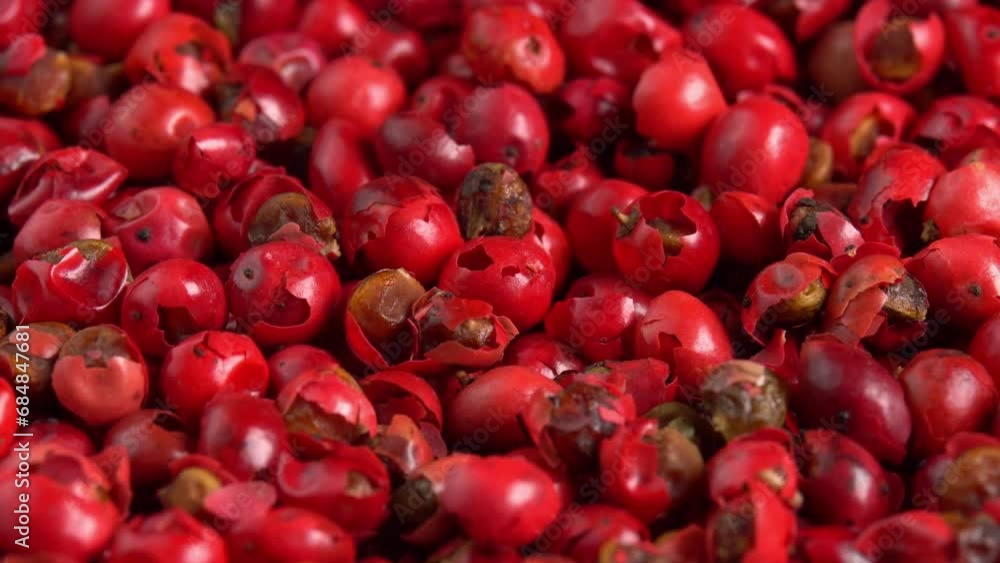 Pink peppercorns or himalayan red pepper berries rotating background in macro. Spice is known as peruvian peppertree or brazilian pepper Pink peppercorns or himalayan red pepper berries rotating background in macro. Spice is known as peruvian peppertree or brazilian pepper