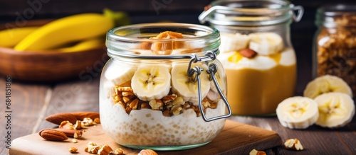Healthy breakfast of banana oatmeal in a jar with nuts and honey, prepared overnight. photo