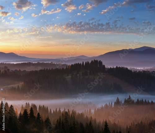 Early morning fog over the autumn slopes of Carpathian Mountains (Yablunytsia village and pass, Ivano-Frankivsk oblast, Ukraine). © wildman
