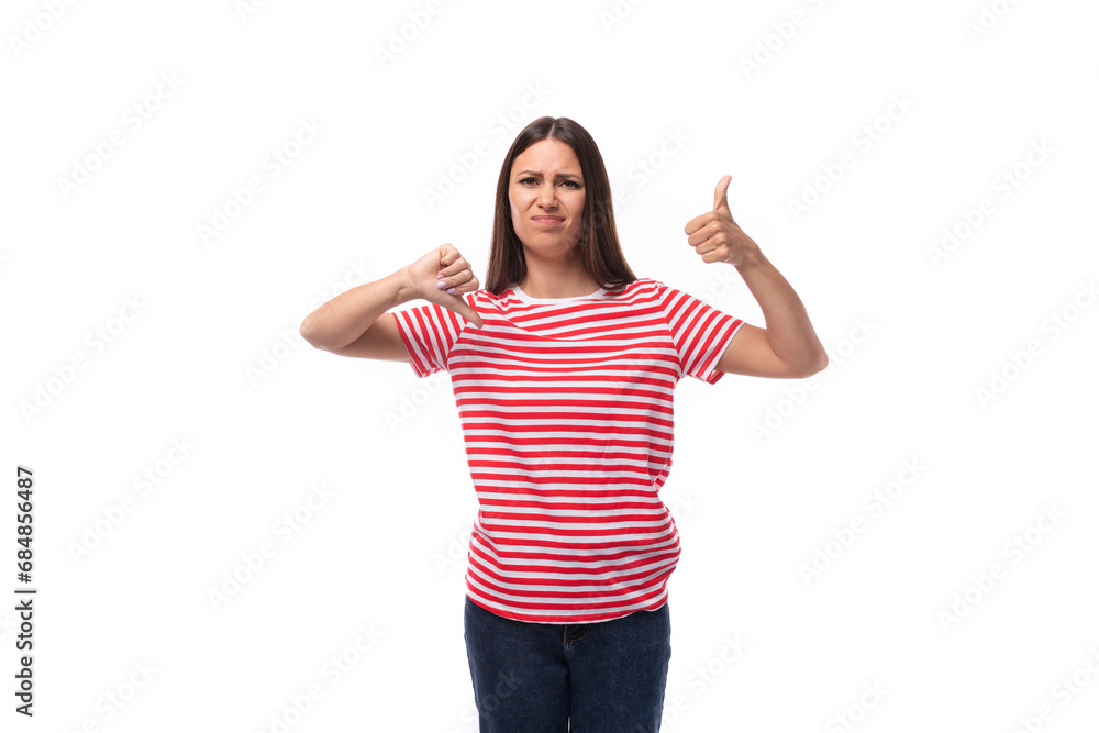 young upset sad european brunette woman dressed in a striped t-shirt on a white background