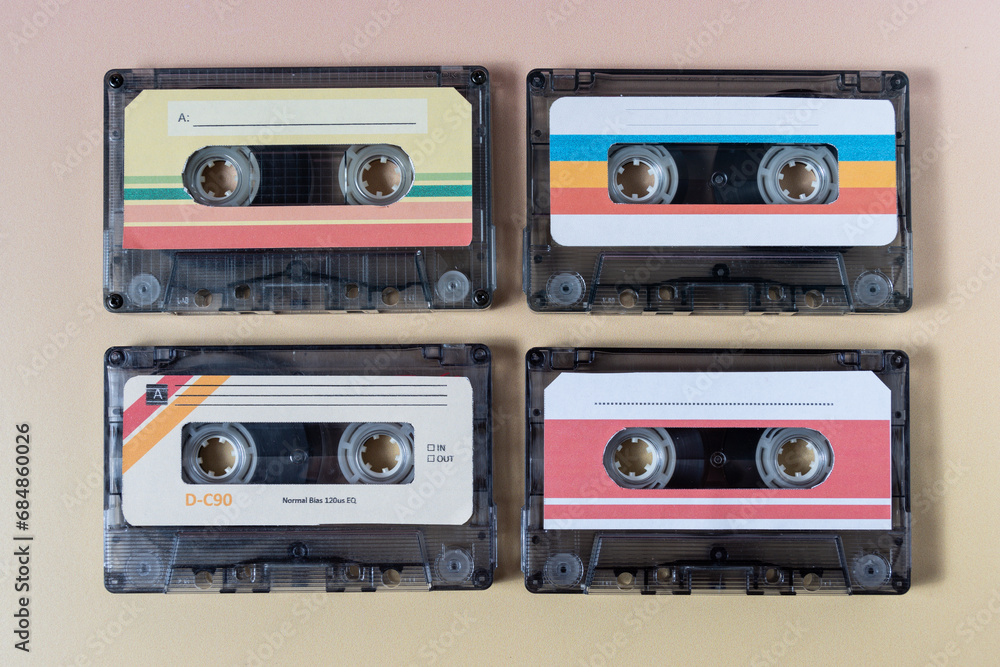 Top view of four music cassettes on a yellow background.