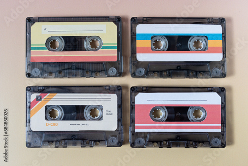 Top view of four music cassettes on a yellow background.