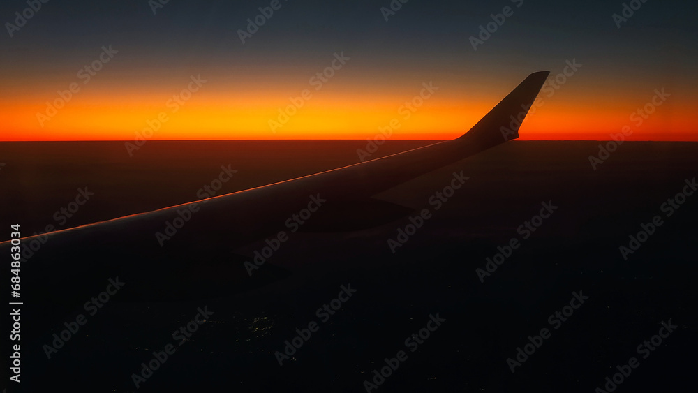 Red sky as seen through window of an airplane Red sky as seen through window of an airplane
